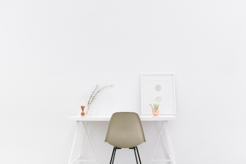 “A beige chair at a small white desk with potted plants and framed art” by Bench Accounting